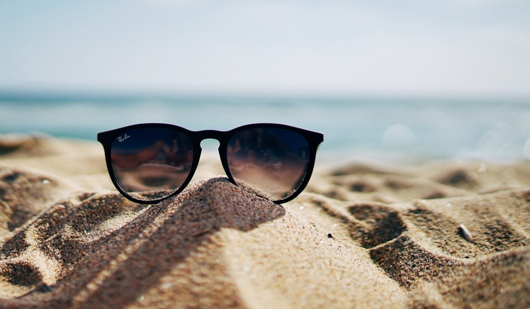 Sunglasses sitting on sand at the beach